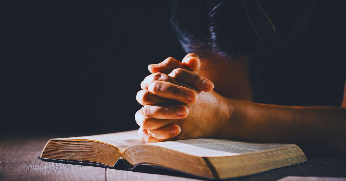 person sitting peacefully with sunlight and open Bible