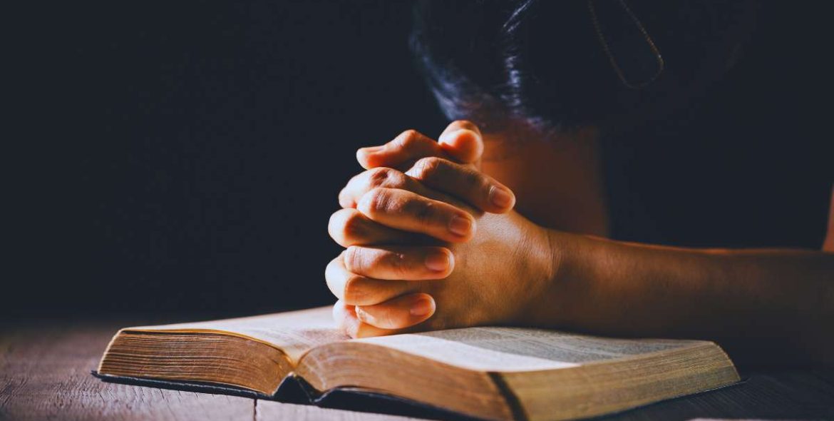 person sitting peacefully with sunlight and open Bible